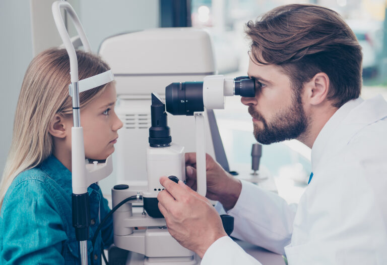 Oftalmólogo controlando la visión de una niña con miopia
