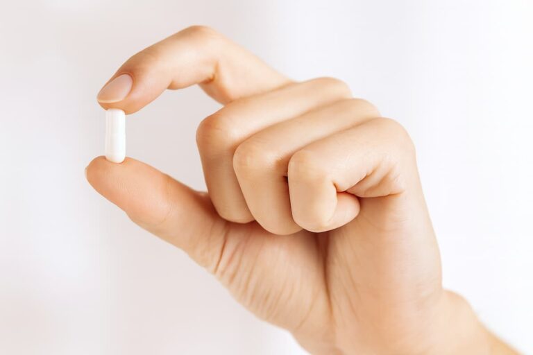 mujer sosteniendo un pellet hormonal en su mano