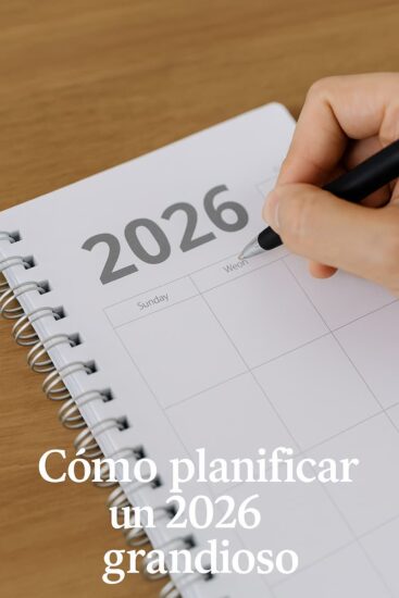 Persona escribiendo en una agenda mientras planifica sus metas para un 2026 grandioso.