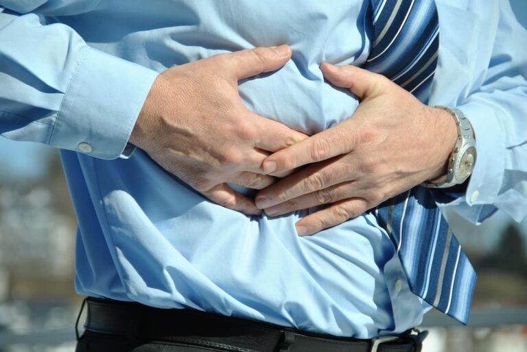 Hombre con dolor estomacal relacionado con irritación intestinal.